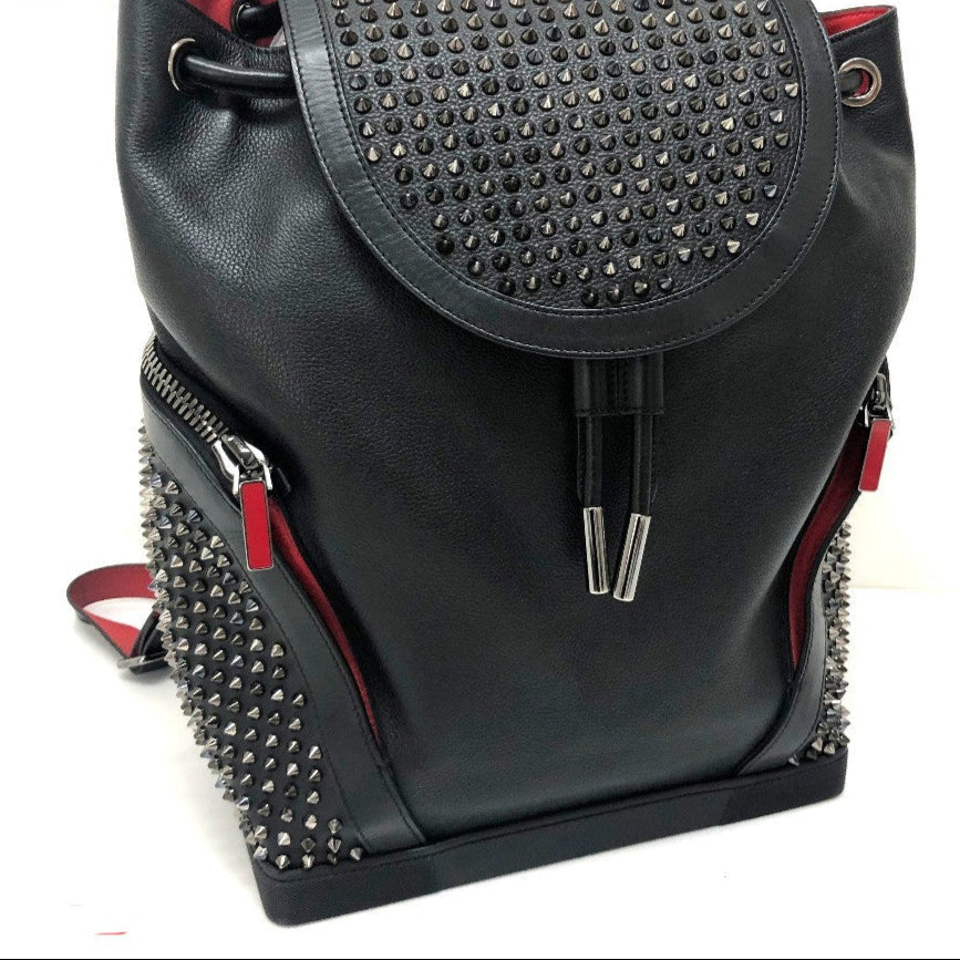 Black studded backpack with red accents on a white background