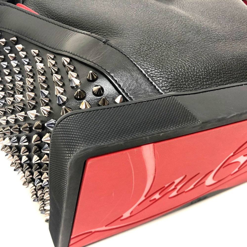 Close-up of a black leather product with silver spikes and red accents, featuring a brand logo.