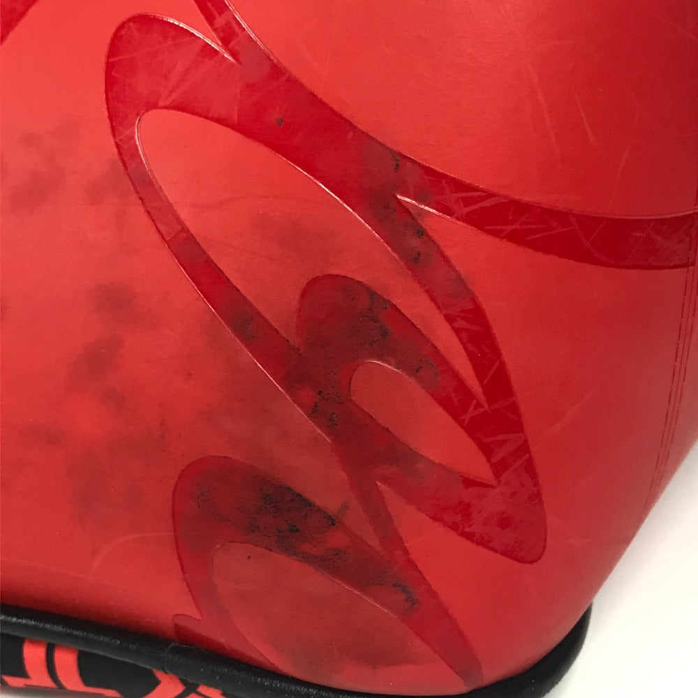 Close-up of a red sports ball with a black logo on a white background