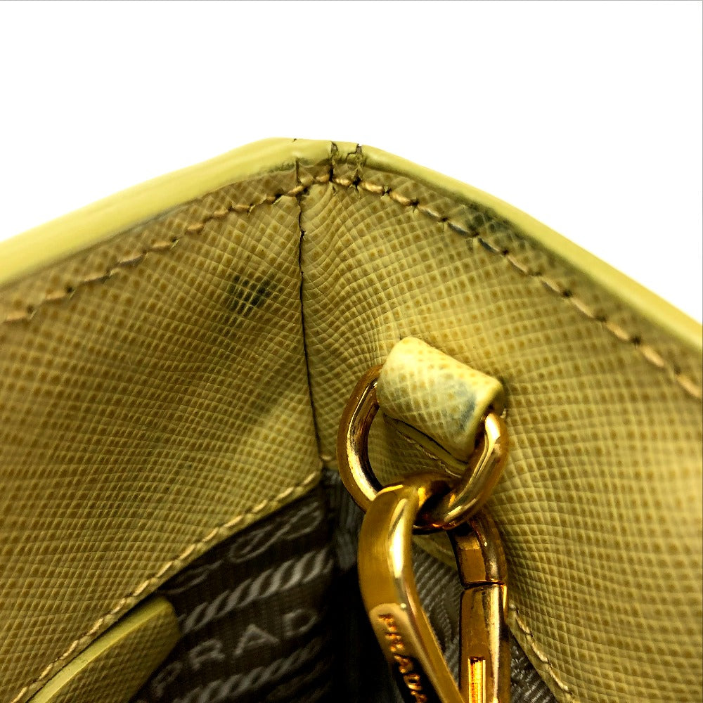 Close-up of a gold Prada handbag with visible branding.