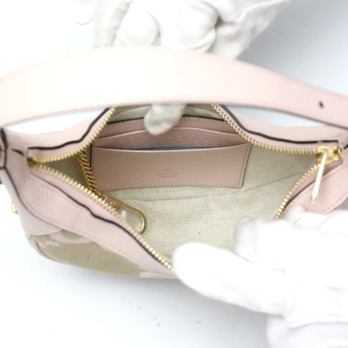 Close-up of a pink handbag with gold zipper on a white background