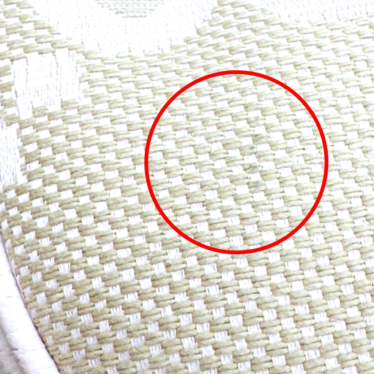 Close-up of woven fabric with a red circle highlighting a defect.