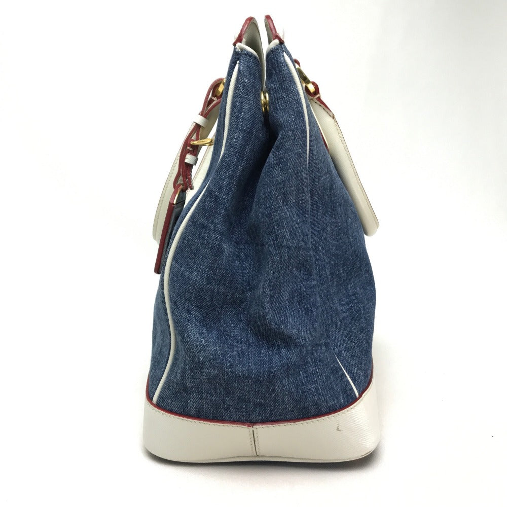 Denim handbag with white base and red stitching on a white background