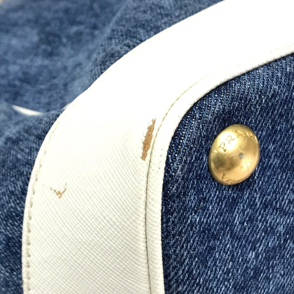 Close-up of a denim jacket with a gold button and white lining.