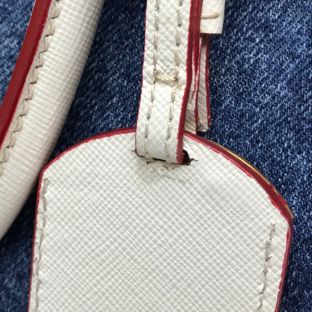 Close-up of a textured white tag with red accents on a denim background