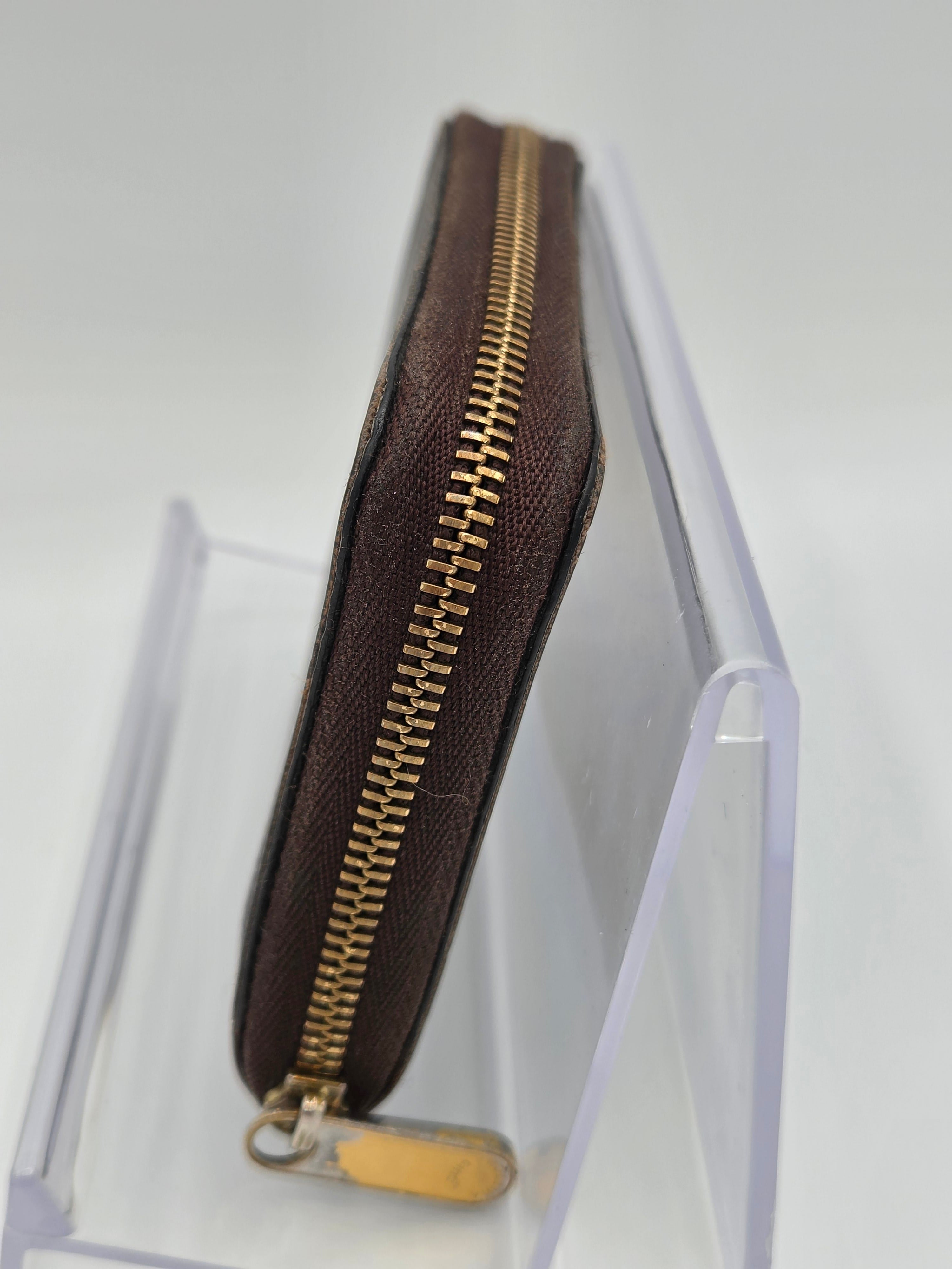 Brown zippered pouch with gold zipper on a white background