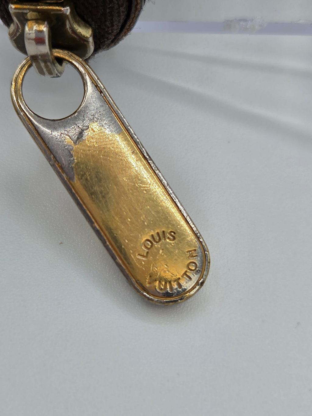Close-up of a gold and silver keychain clasp on a white background