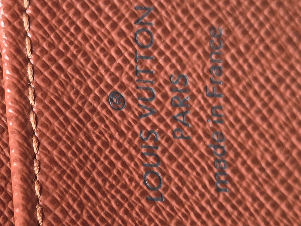 Louis Vuitton wallet with brand name and 'made in France' text on brown leather.