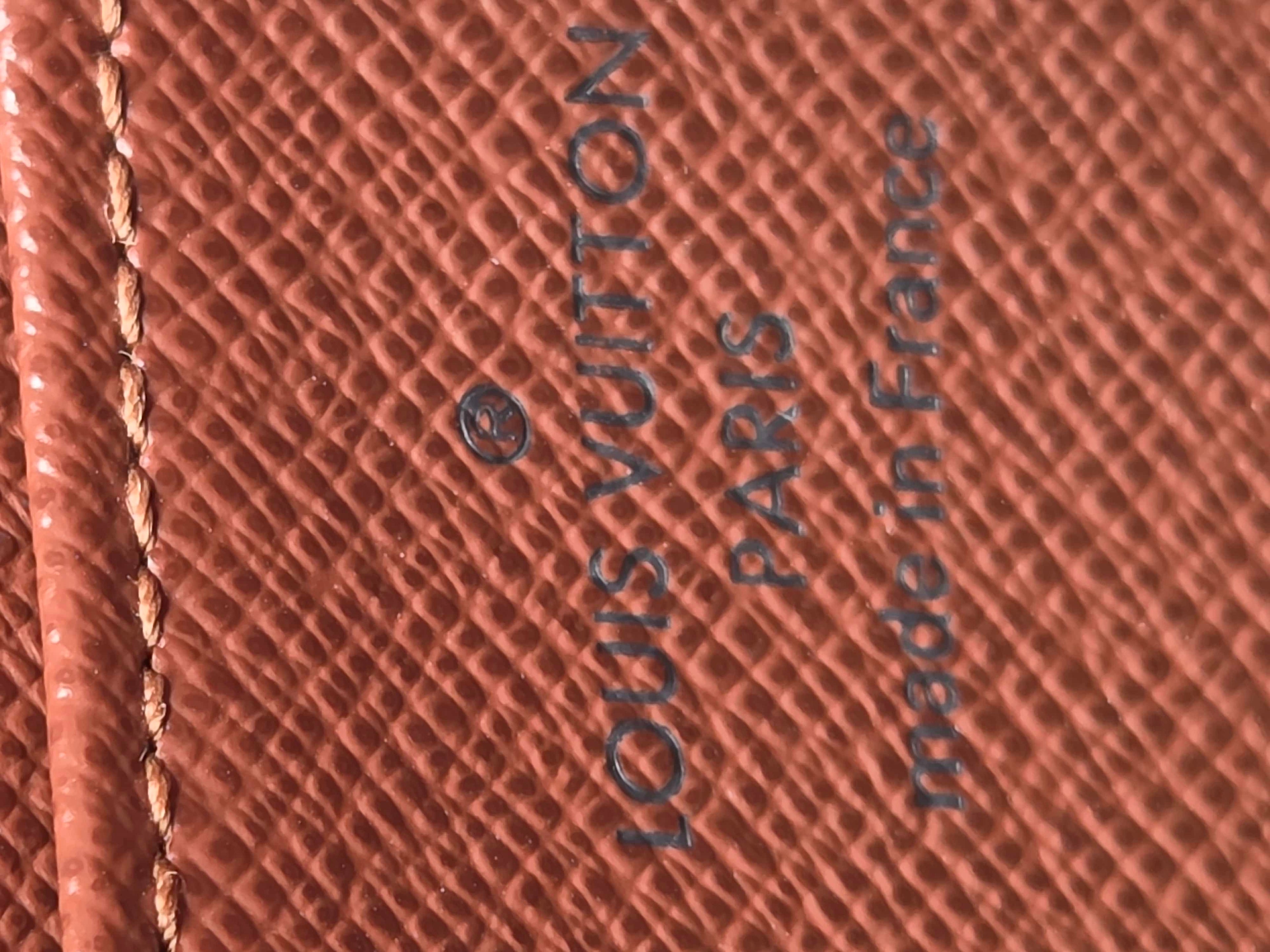 Louis Vuitton wallet with brand name and 'made in France' text on brown leather.