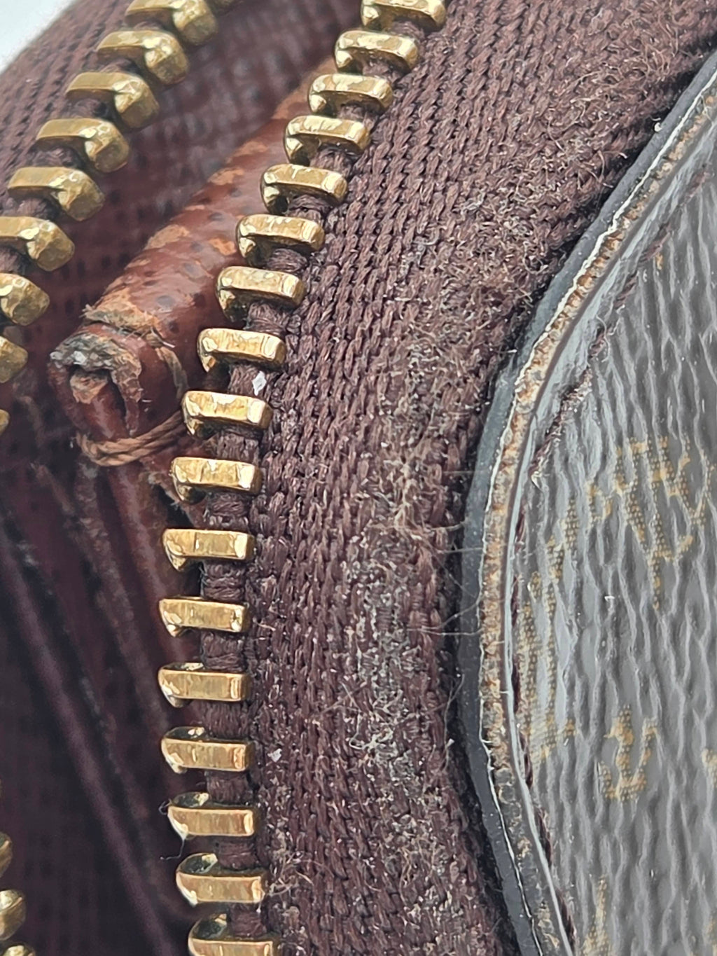 Close-up of a textured brown fabric surface with gold zipper details
