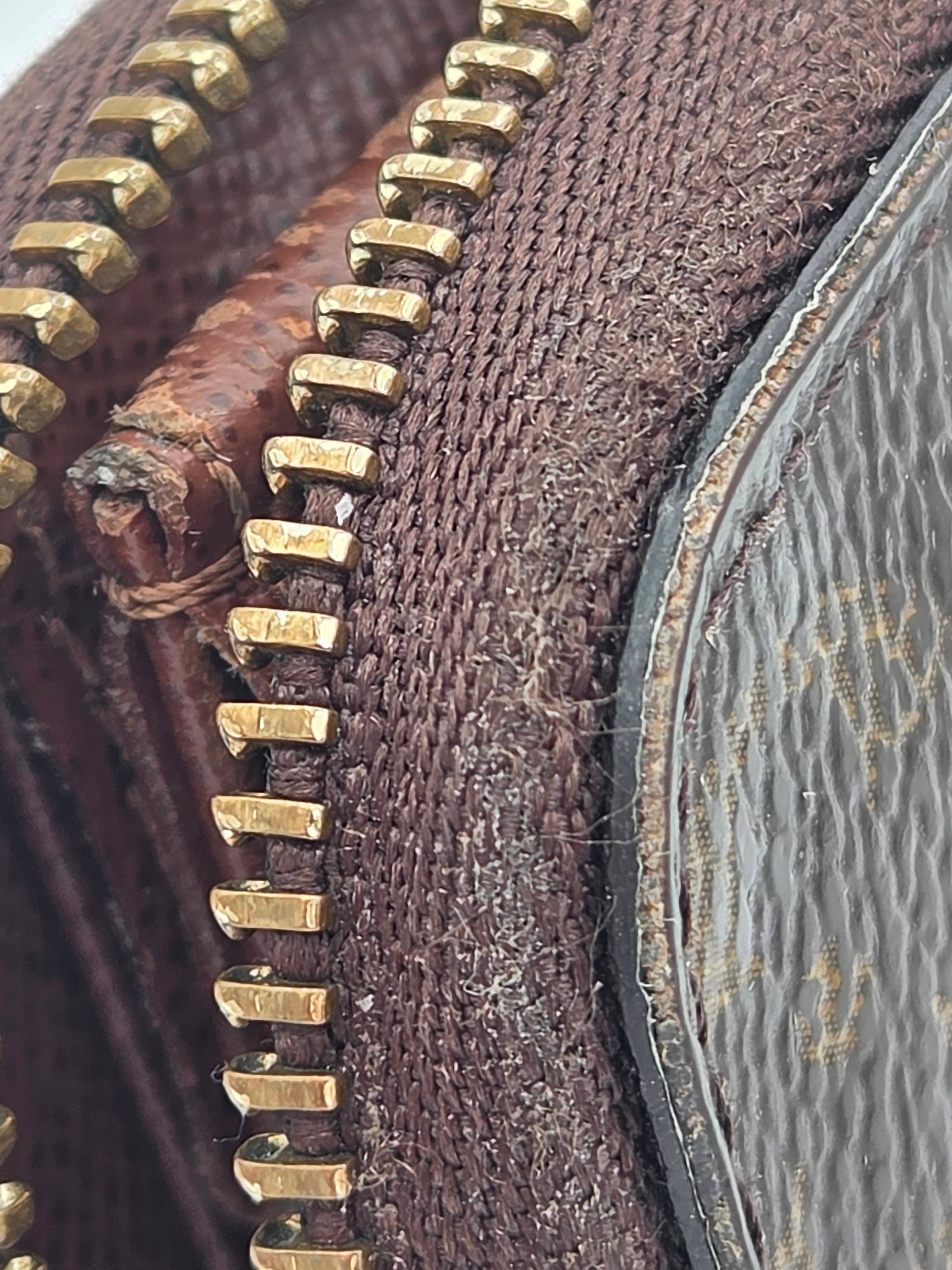 Close-up of a textured brown fabric surface with gold zipper details