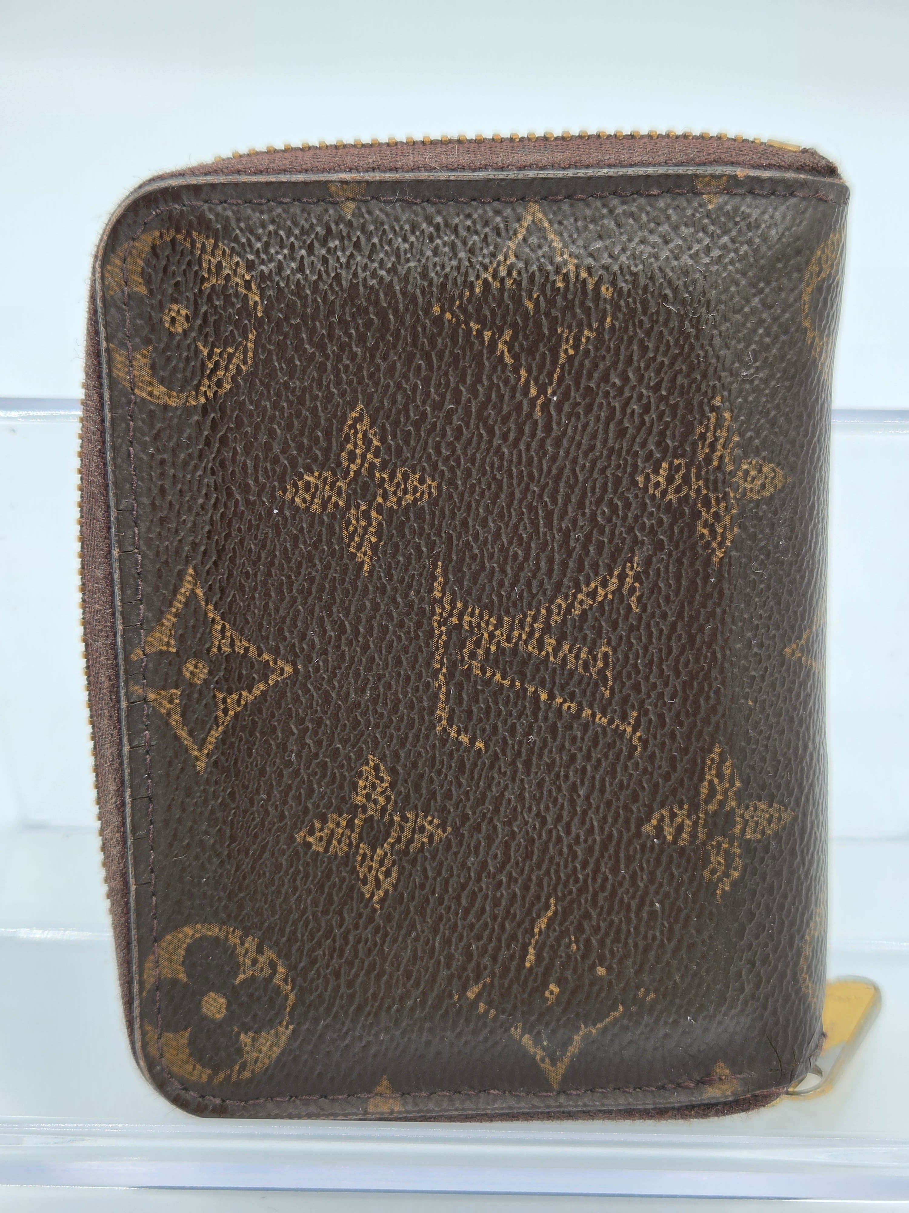 Brown Louis Vuitton wallet with monogram pattern on a white background