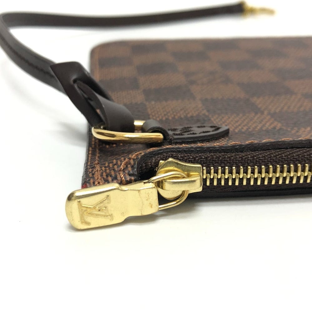 Close-up of a brown patterned handbag with gold zipper and clasp on a white background