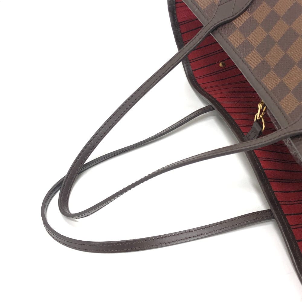 Close-up of a brown leather handbag with a checkered pattern on a white background