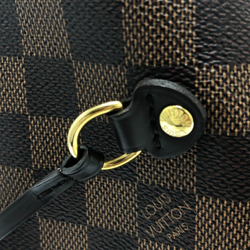 Close-up of a Louis Vuitton handbag with a gold clasp and black strap.