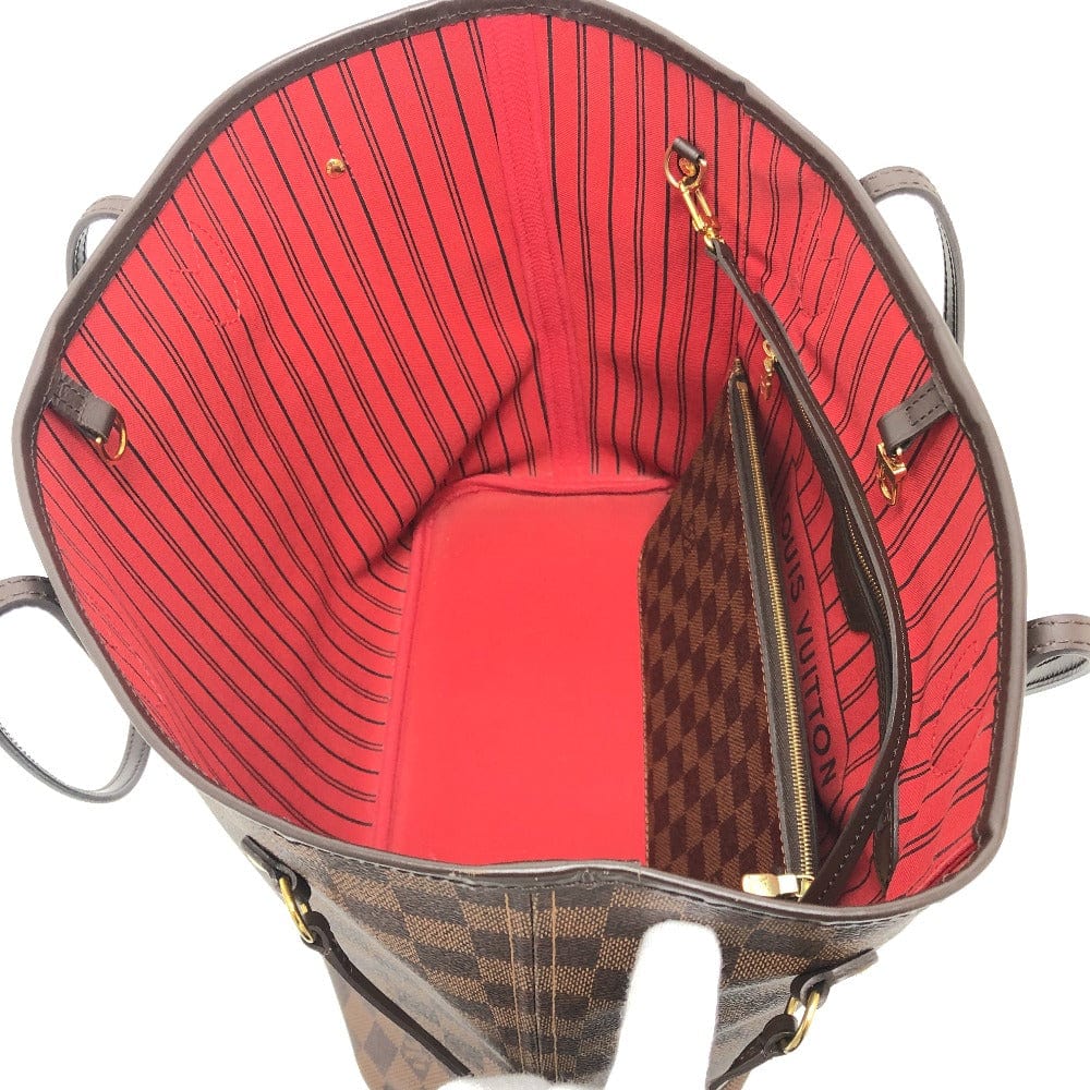 Open handbag showing red interior and patterned exterior.