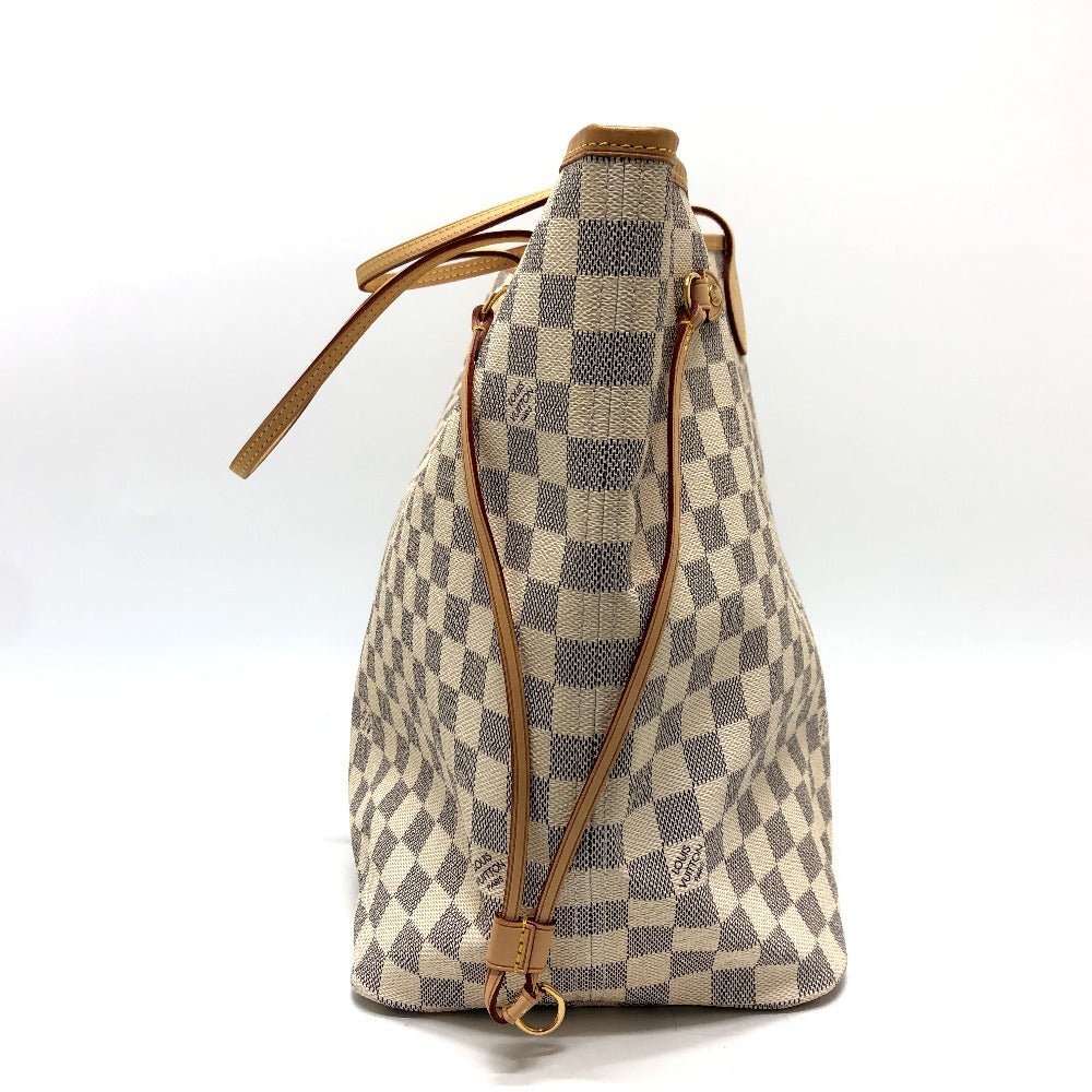 Checkered handbag with brown leather accents on a white background