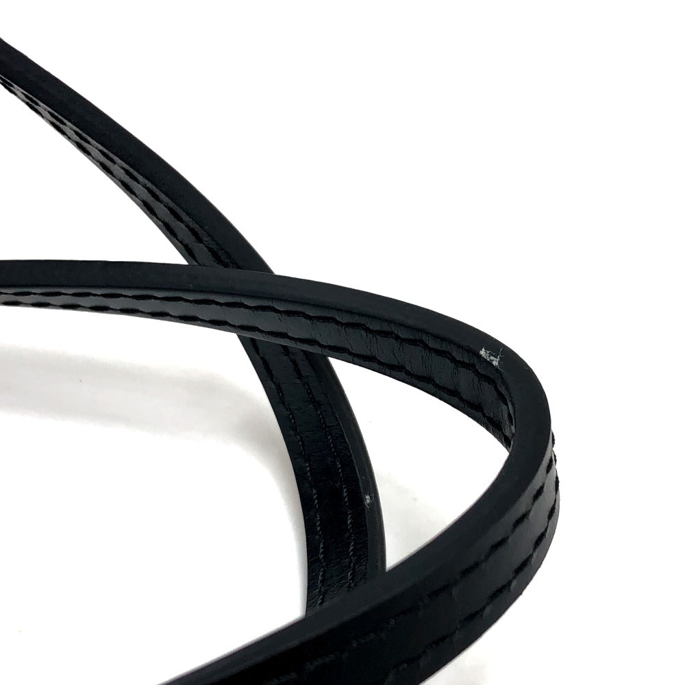 Close-up of a black belt with visible stitching on a white background