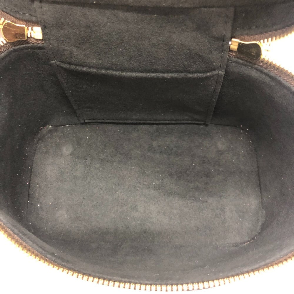 Close-up of a black interior of a handbag with gold zipper.