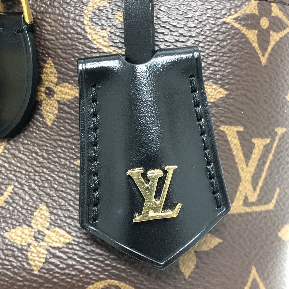 Black leather keychain with gold 'LV' logo on a patterned background