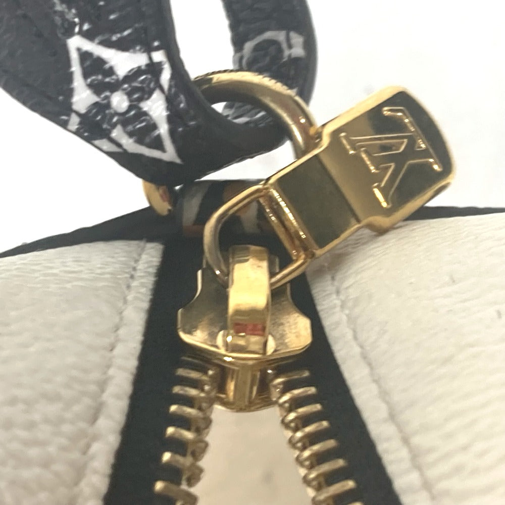 Close-up of a gold zipper pull on a black and white textured surface