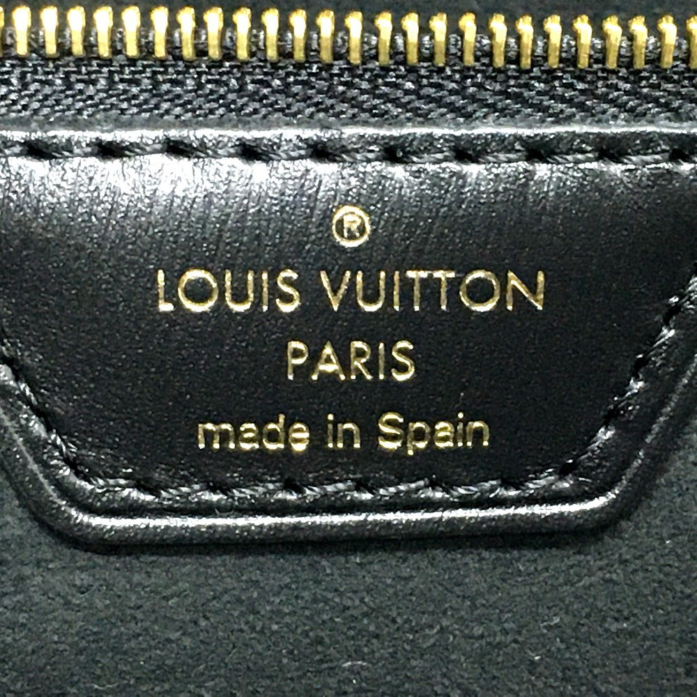 Louis Vuitton label on a black leather product with gold lettering.