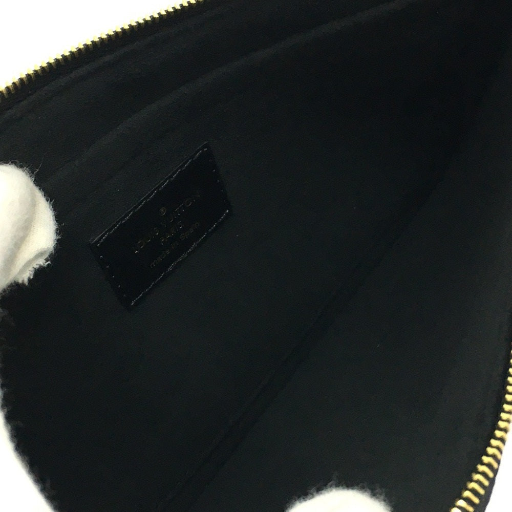 Close-up of a black pouch with a brand label and white fur trim.