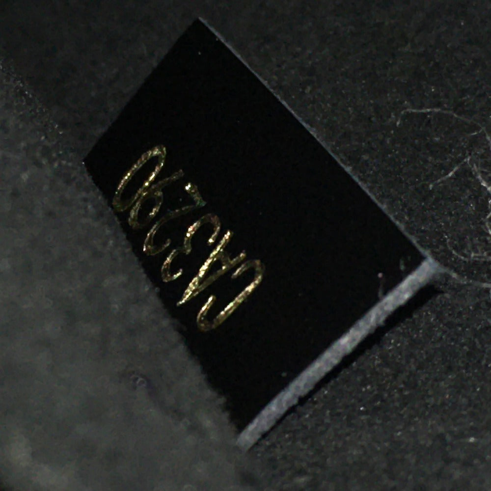 Small black rectangular component with gold text on a dark textured background