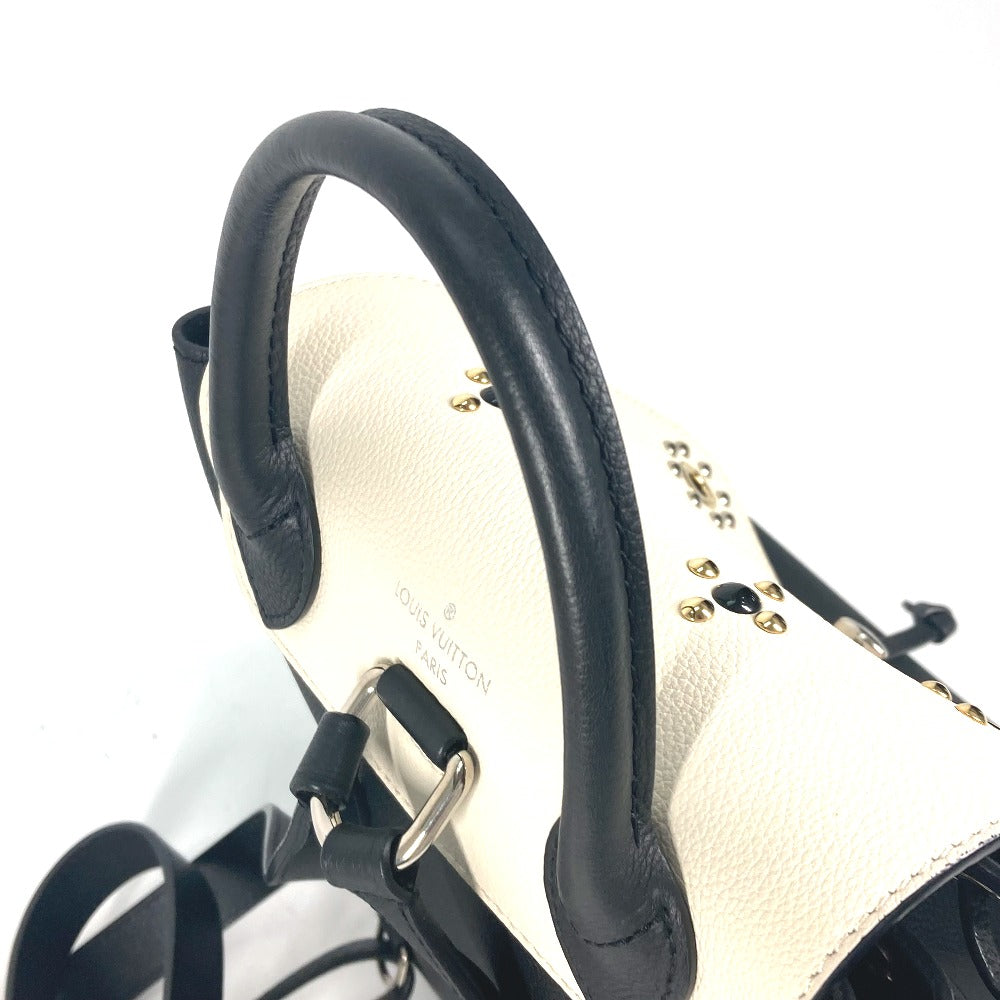 Close-up of a black handbag with gold accents on a white background