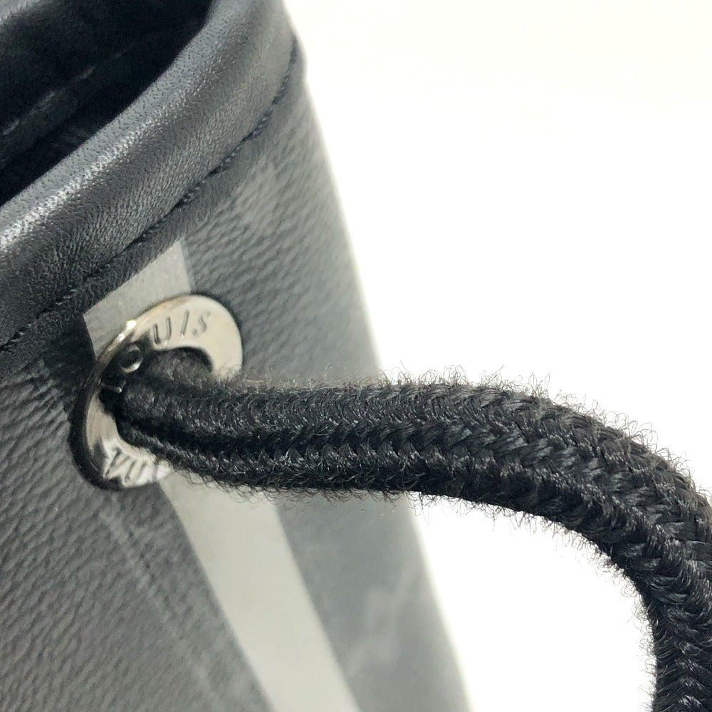 Close-up of a black leather bag with a braided handle and visible brand tag.