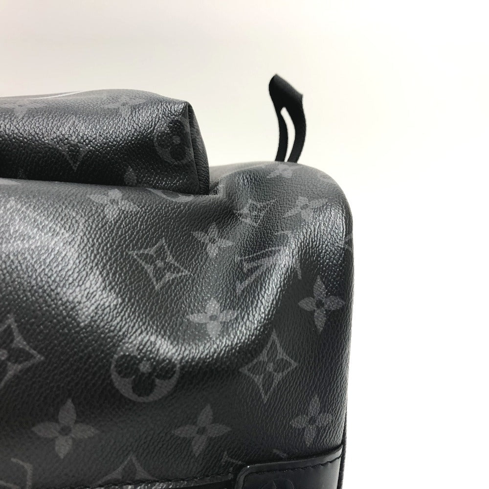 Close-up of a black leather bag with a brand logo on a light gray background