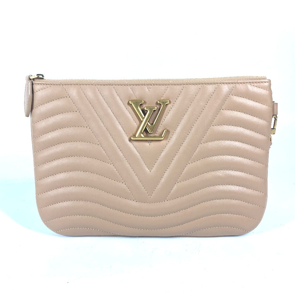 Beige handbag with a gold logo on a light blue background