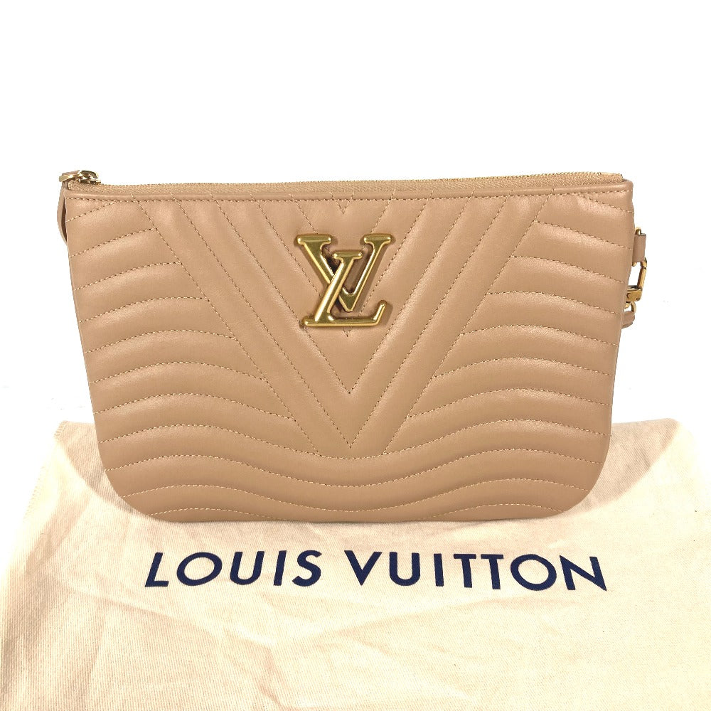 Beige quilted handbag with gold logo on a Louis Vuitton dust bag