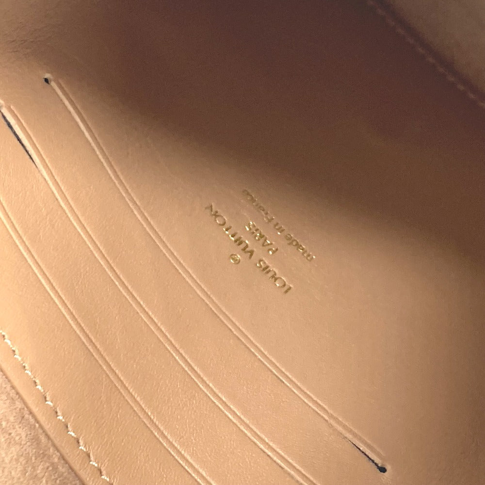 Close-up of a beige leather surface with 'Louis Vuitton' branding.