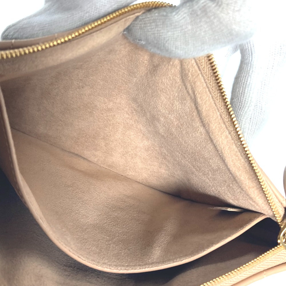 Close-up of a beige handbag with a gold zipper