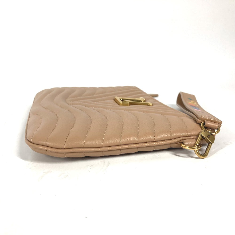 Beige quilted handbag with gold hardware on a white background