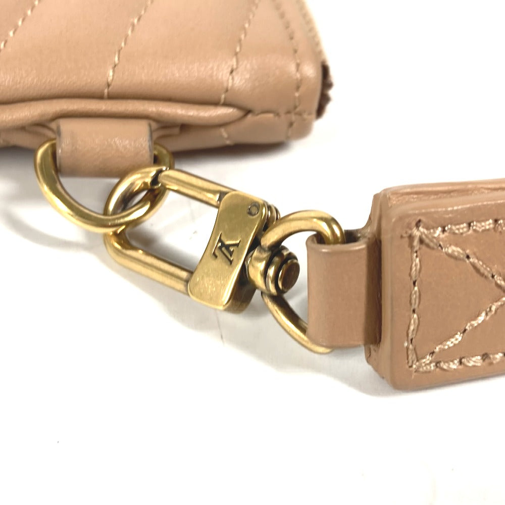 Close-up of a beige handbag with a gold clasp on a white background