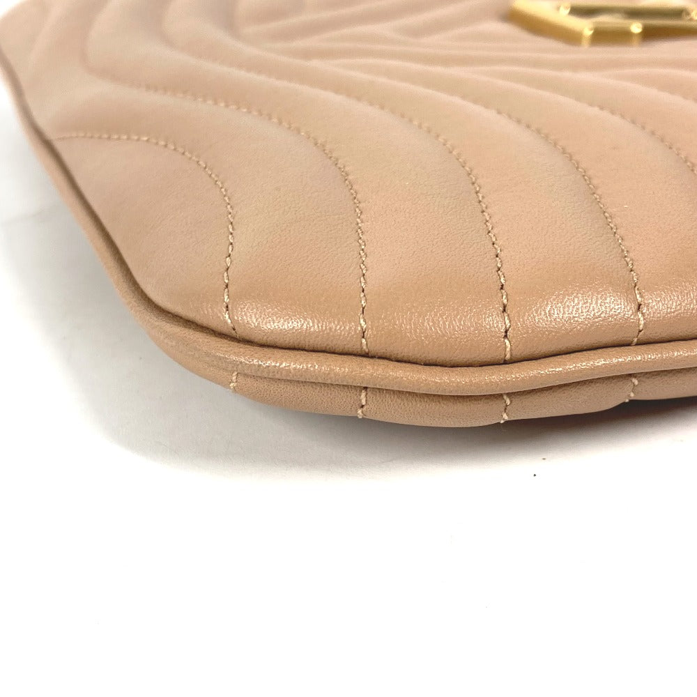 Close-up of a beige quilted handbag with a gold clasp on a white background