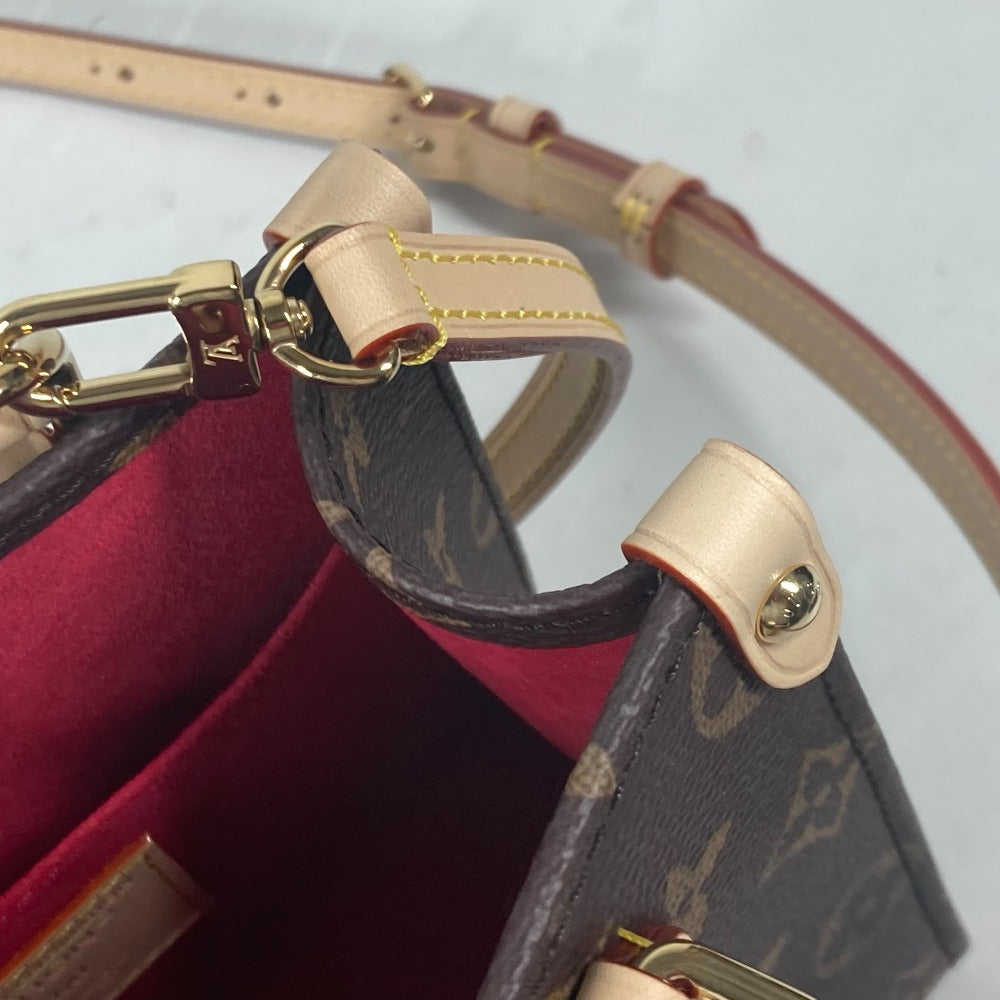 Close-up of a brown handbag with gold hardware on a light gray background