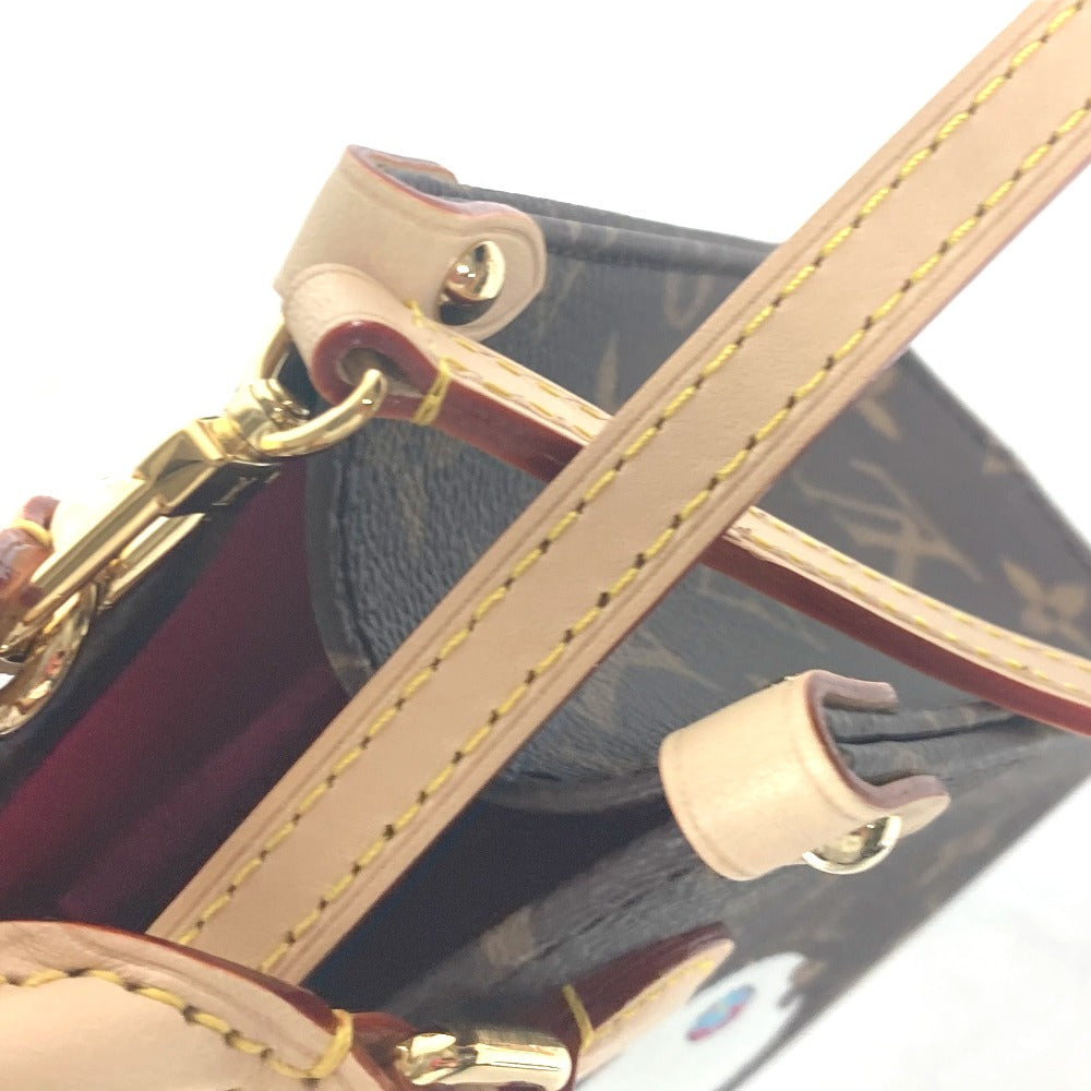 Close-up of a handbag with beige strap and gold hardware on a reflective surface.