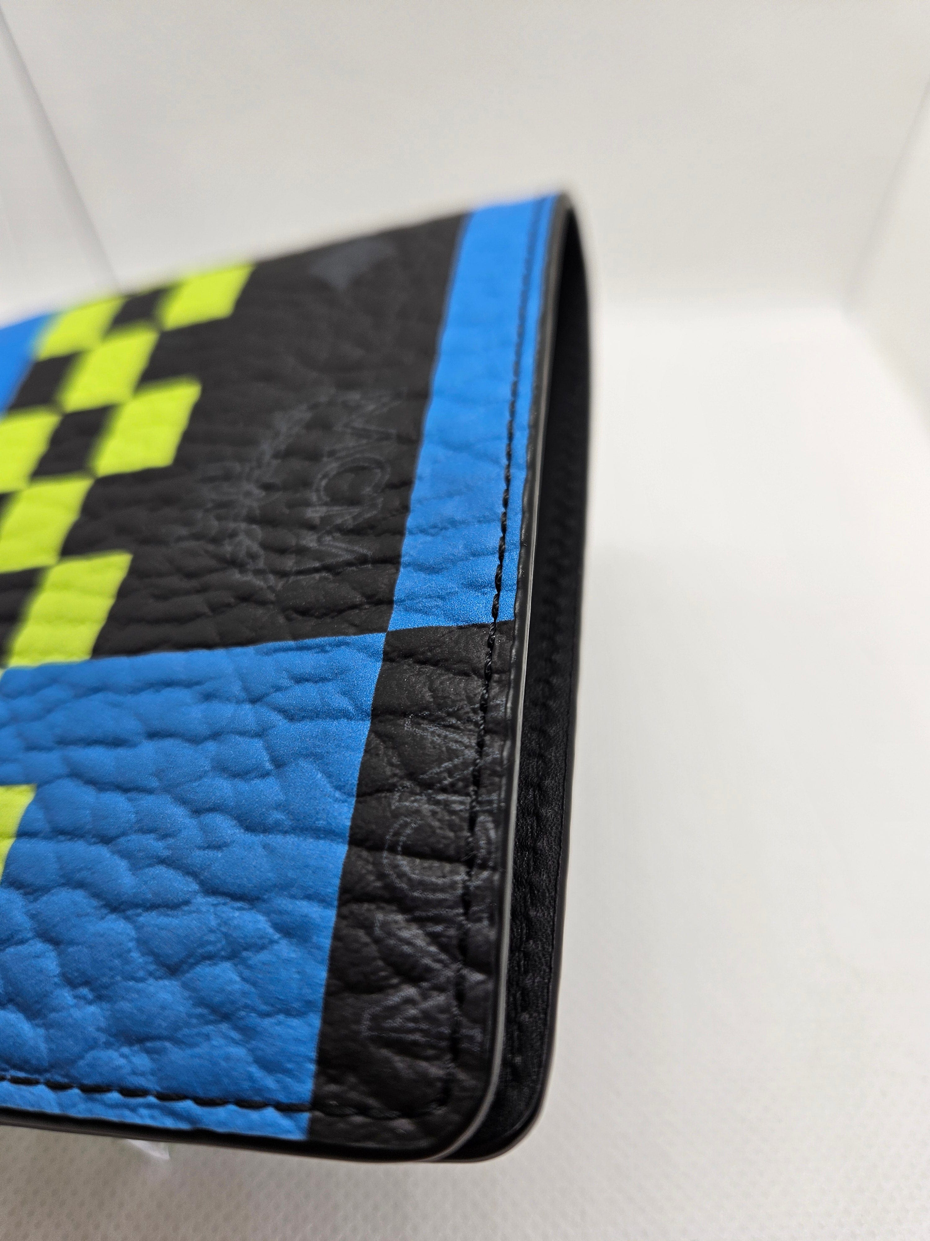 Close-up of a wallet with blue, black, and yellow checkered pattern on a white background
