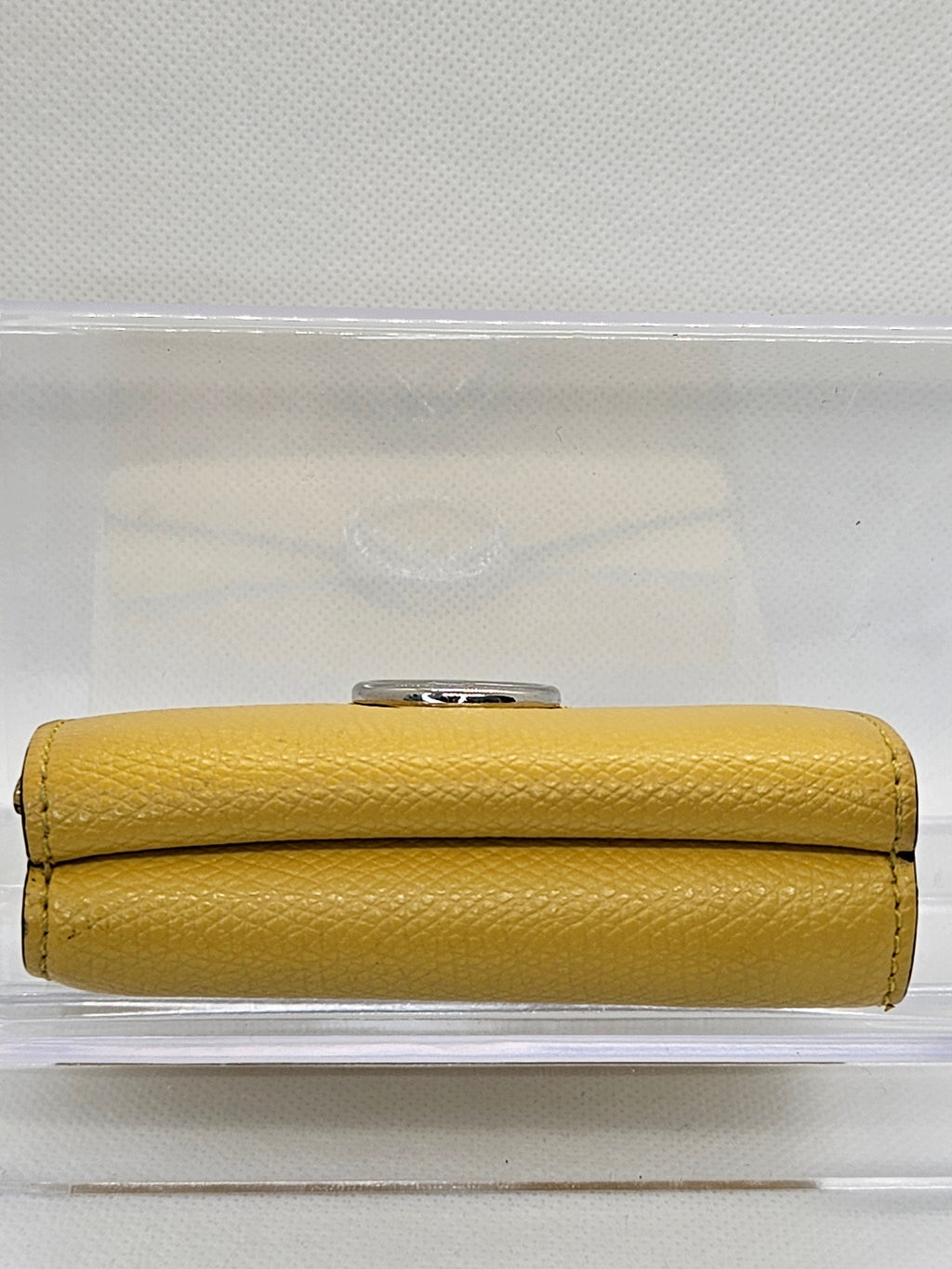 Yellow wallet with a metallic clasp on a white background