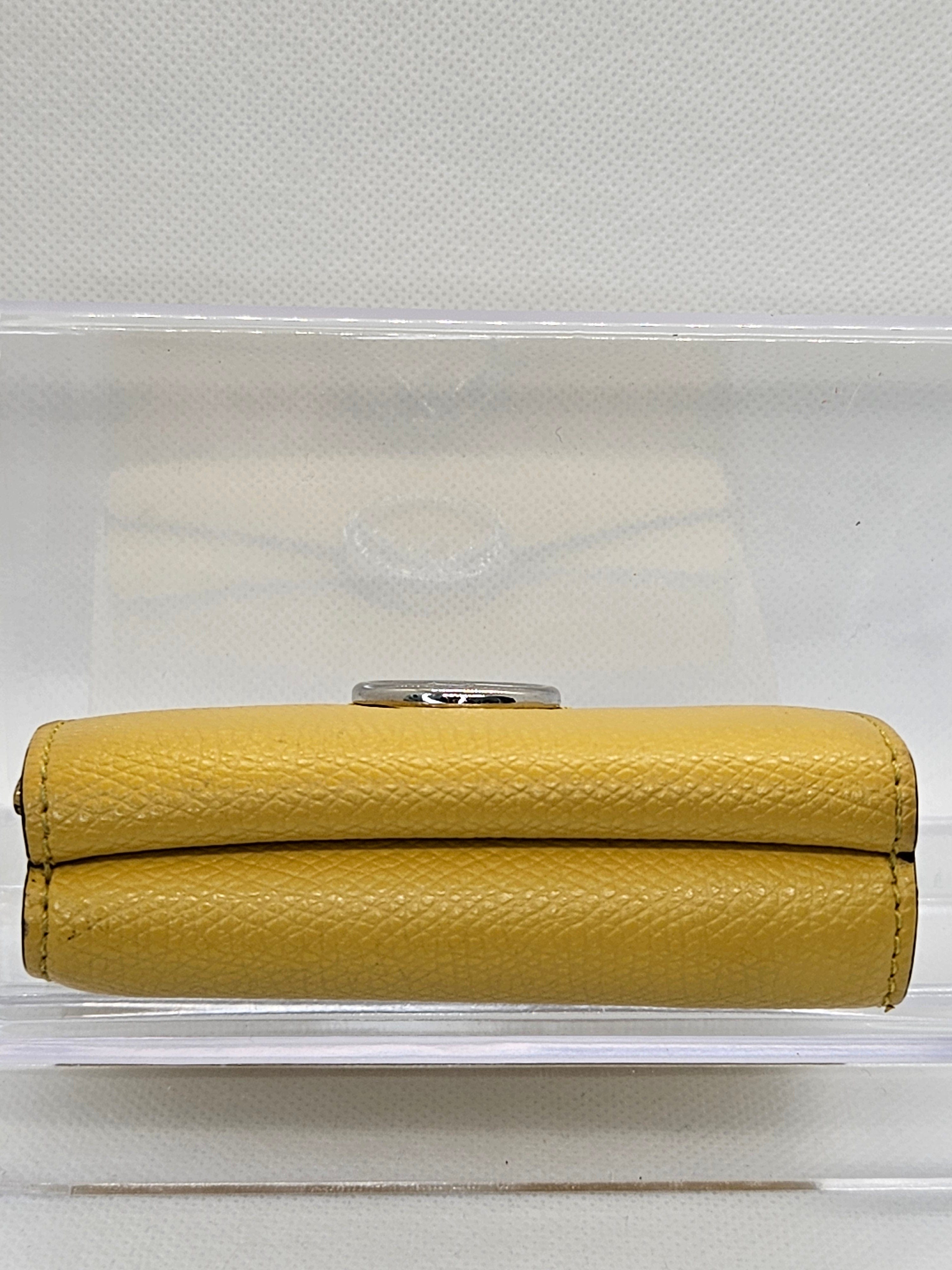 Yellow wallet with a metallic clasp on a white background