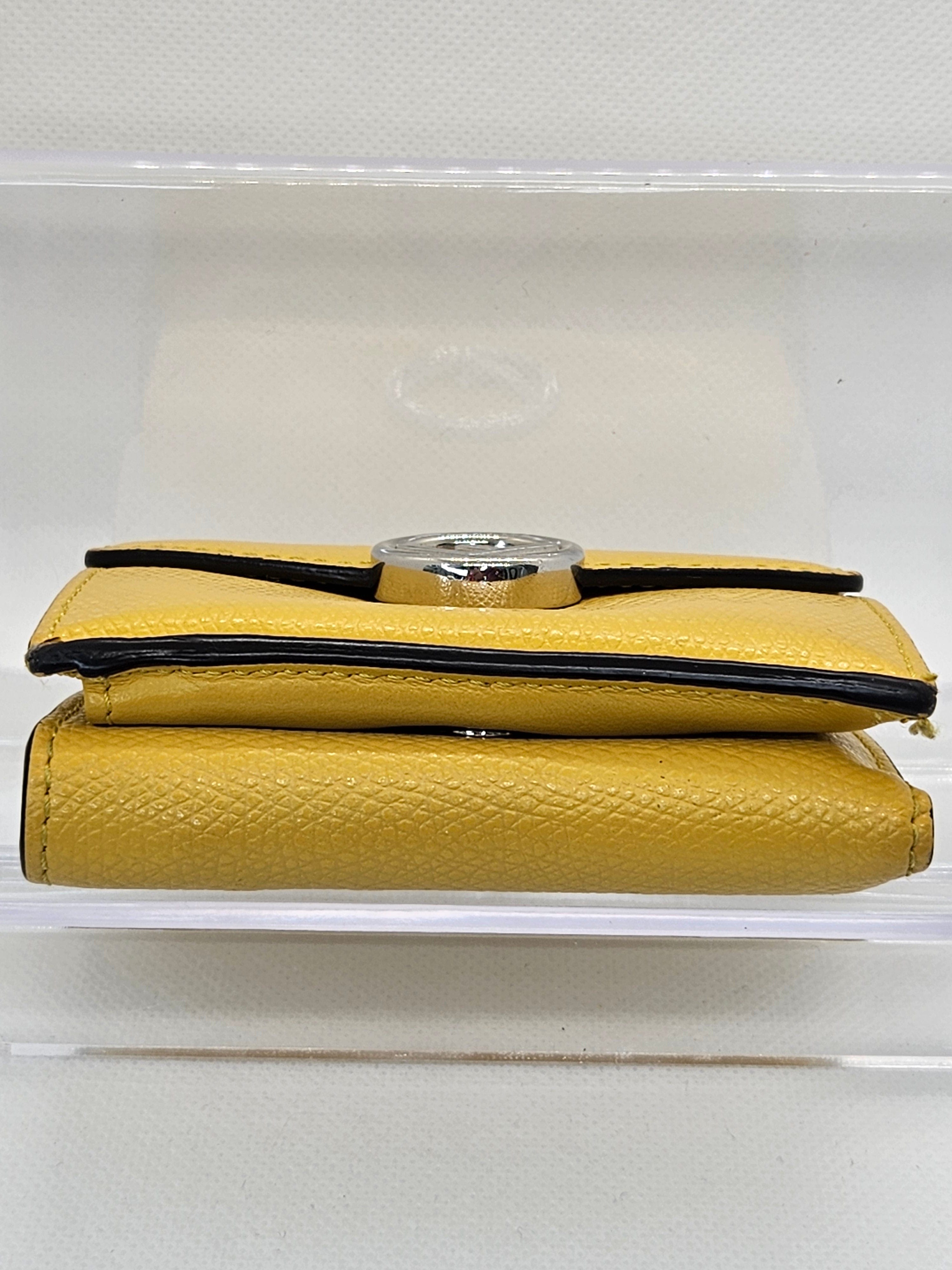 Yellow clutch bag with a black strap on a white background
