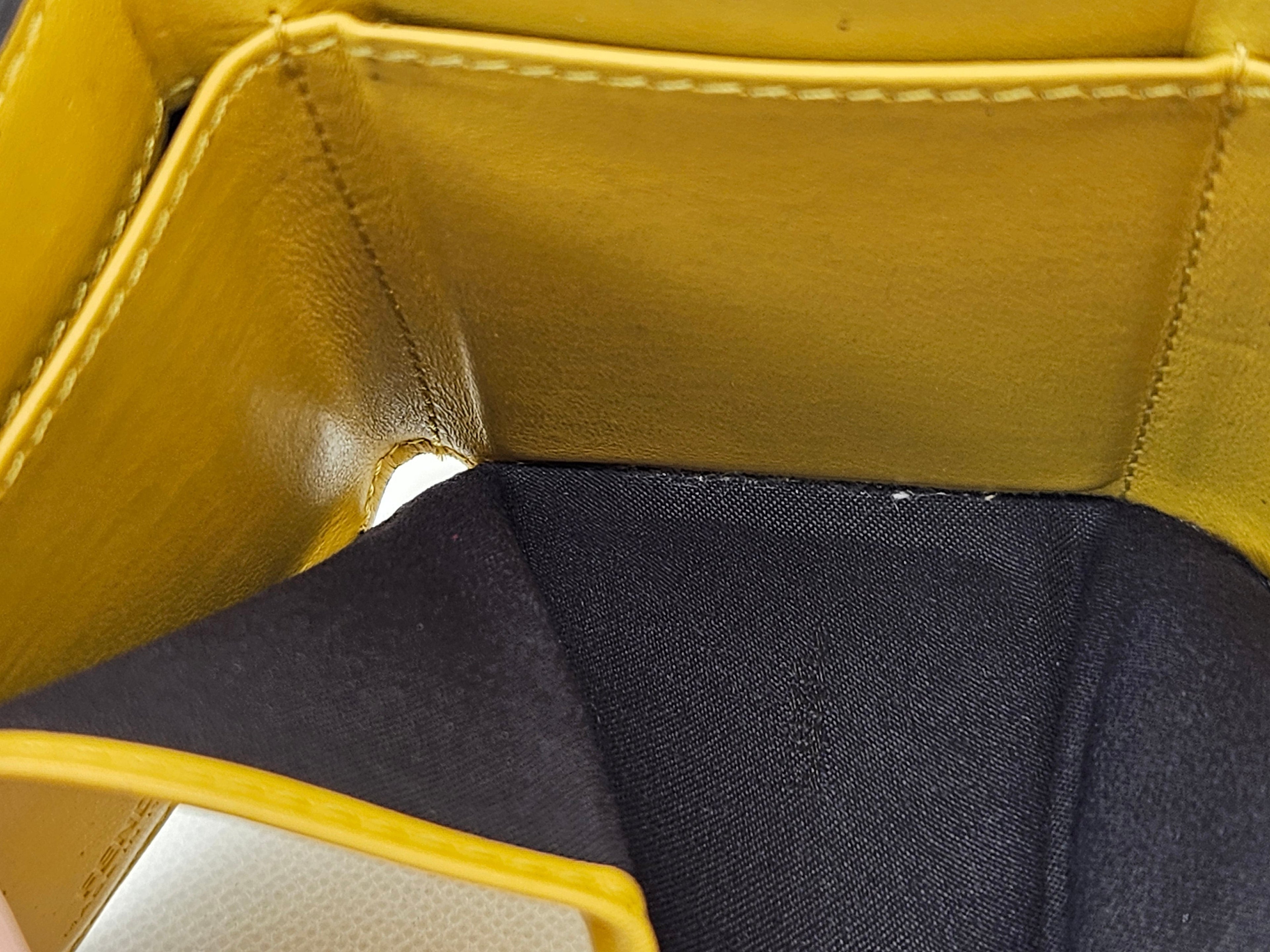 Close-up of a yellow leather product with a black interior