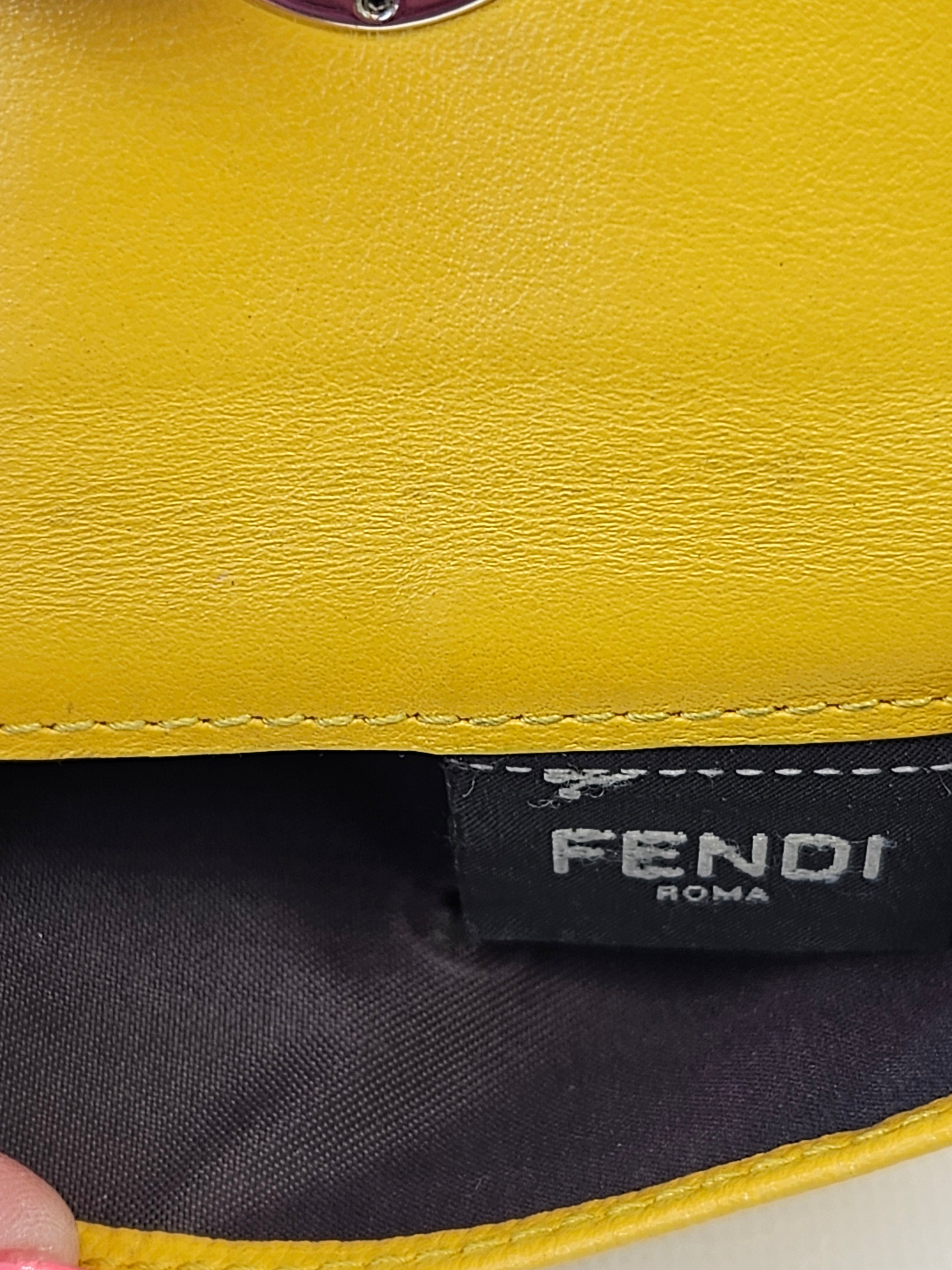 Close-up of a yellow leather product with 'Fendi' branding.
