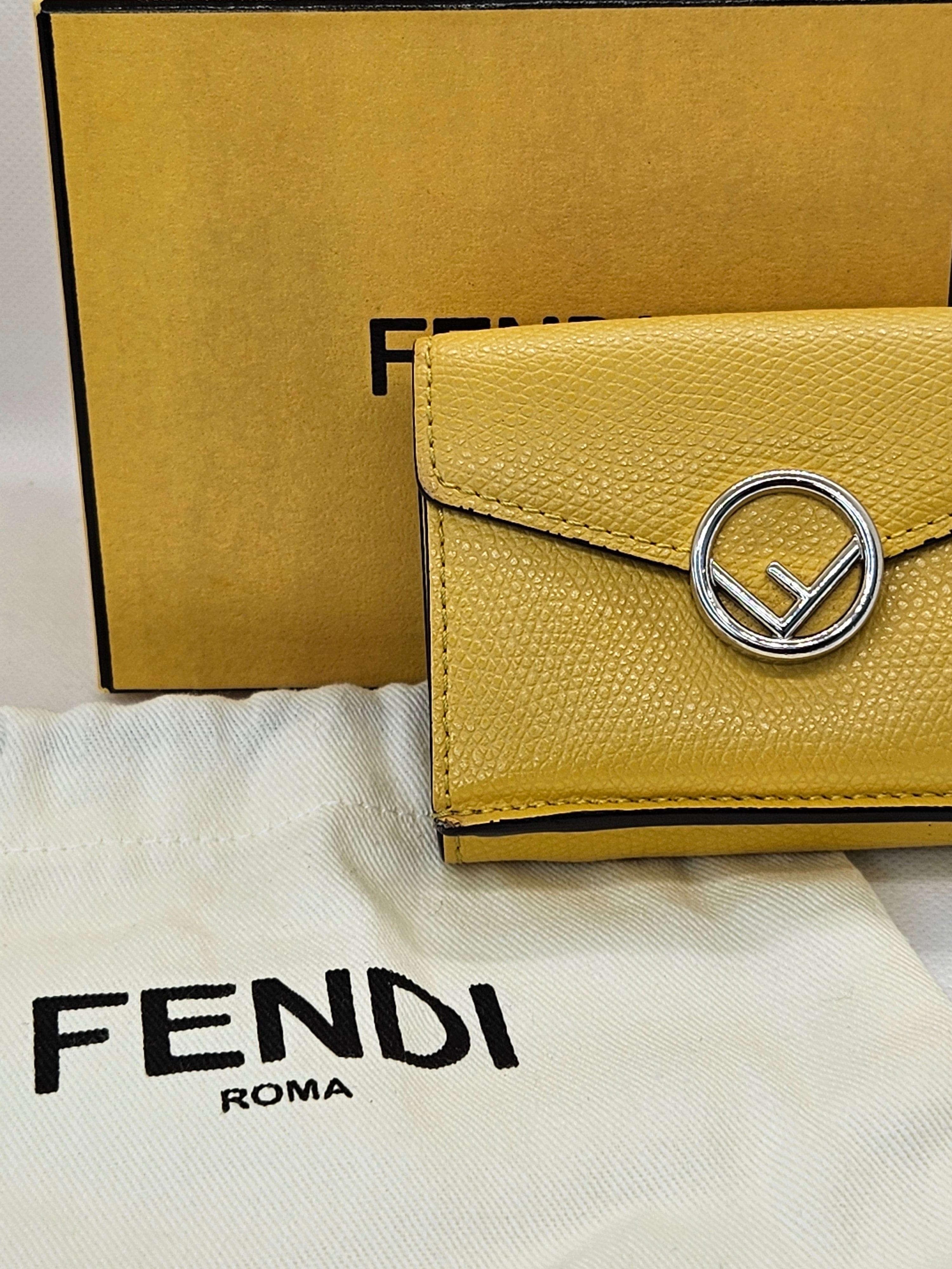 Yellow Fendi wallet with logo on a branded pouch and box
