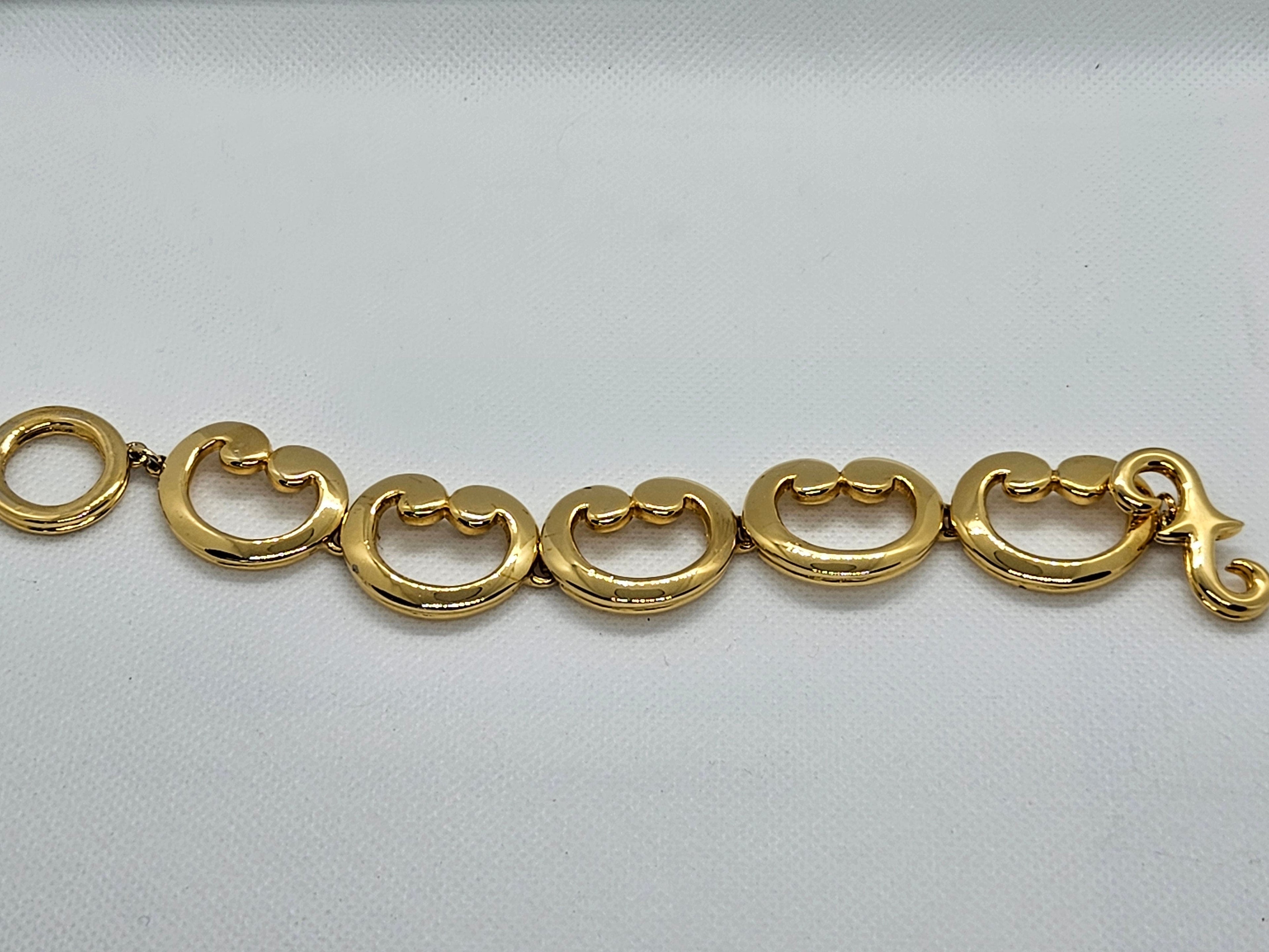 Gold bracelet on a light gray background