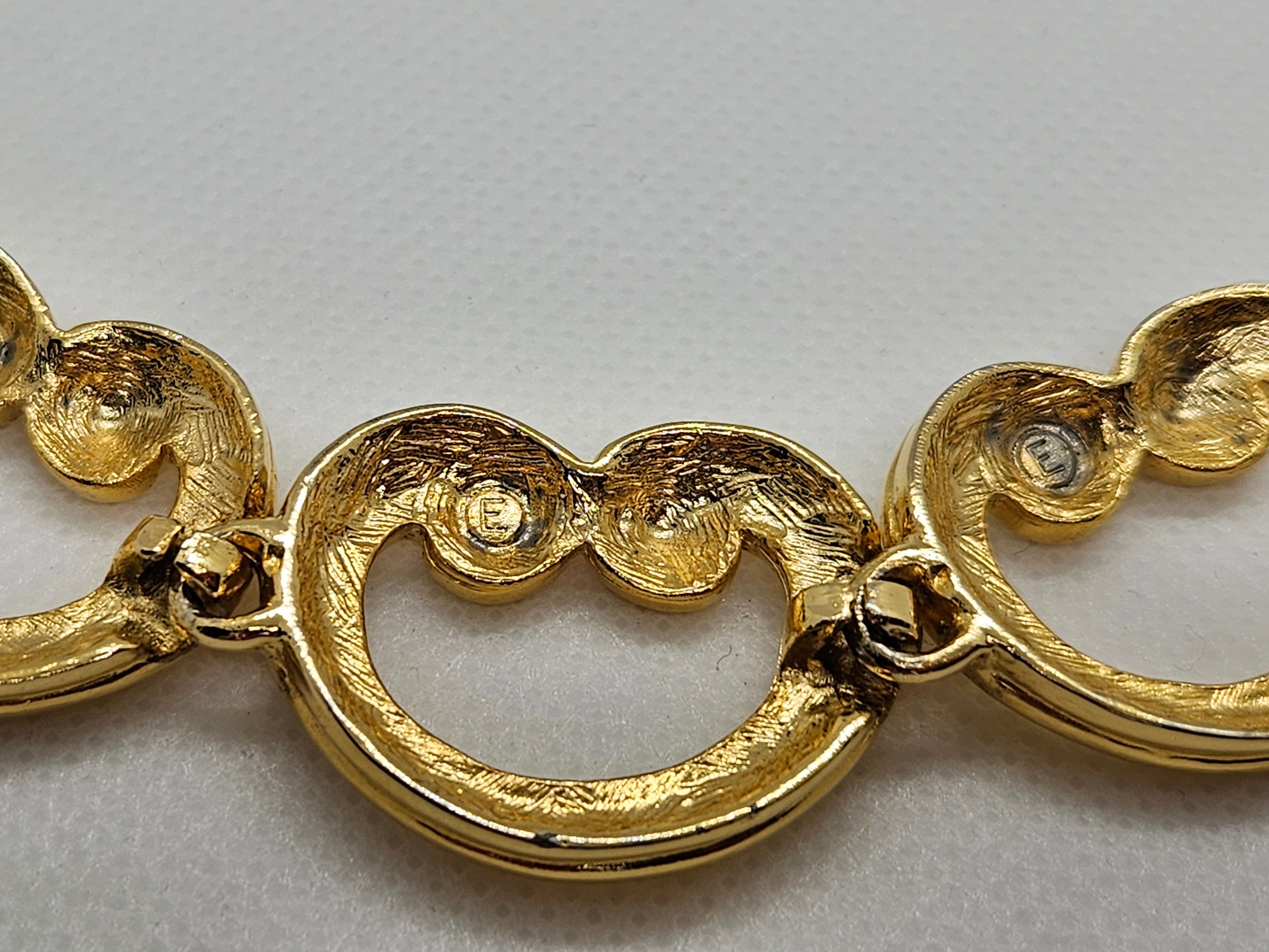 Close-up of a gold bracelet on a light gray background