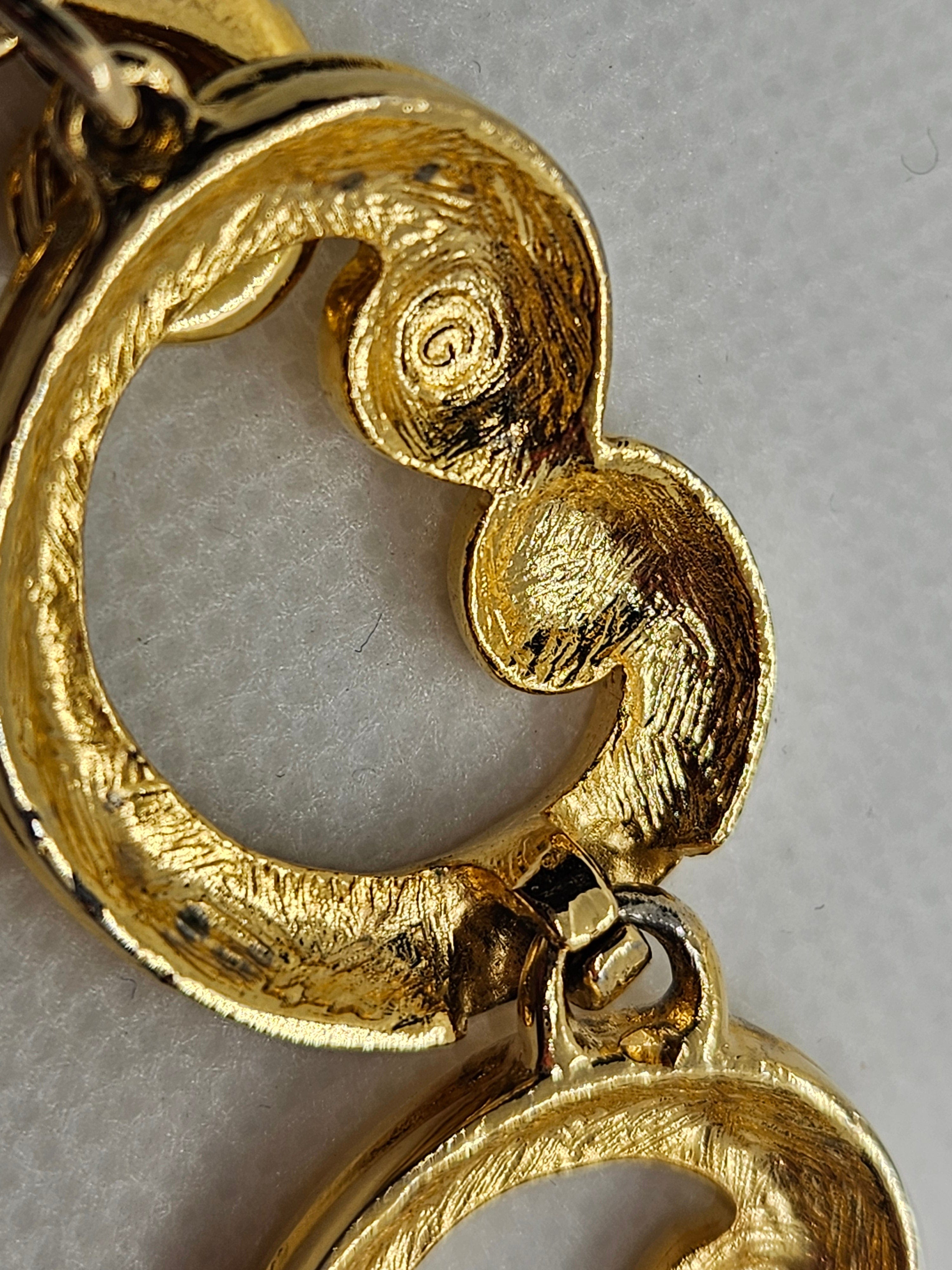 Close-up of a gold bracelet with intricate design on a gray background